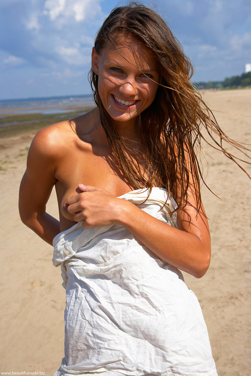 Naked teen poses in the sand-00